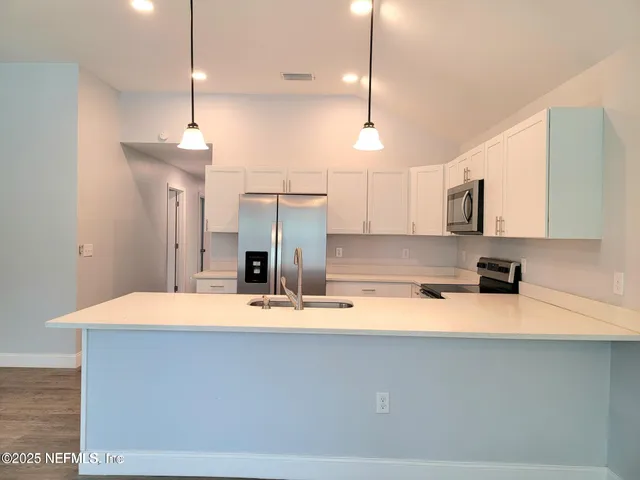 a kitchen with a refrigerator a sink and a large window