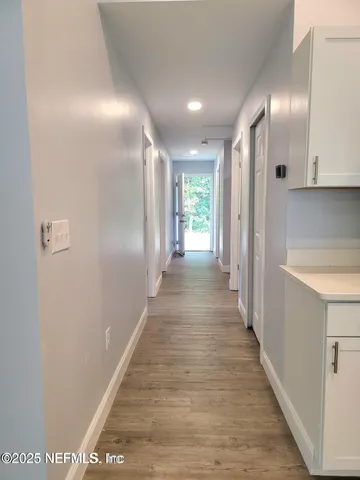 a view of a hallway with wooden floor