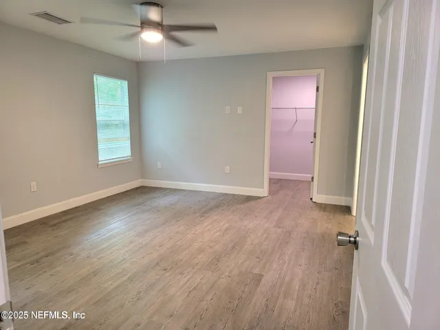 an empty room with wooden floor and window