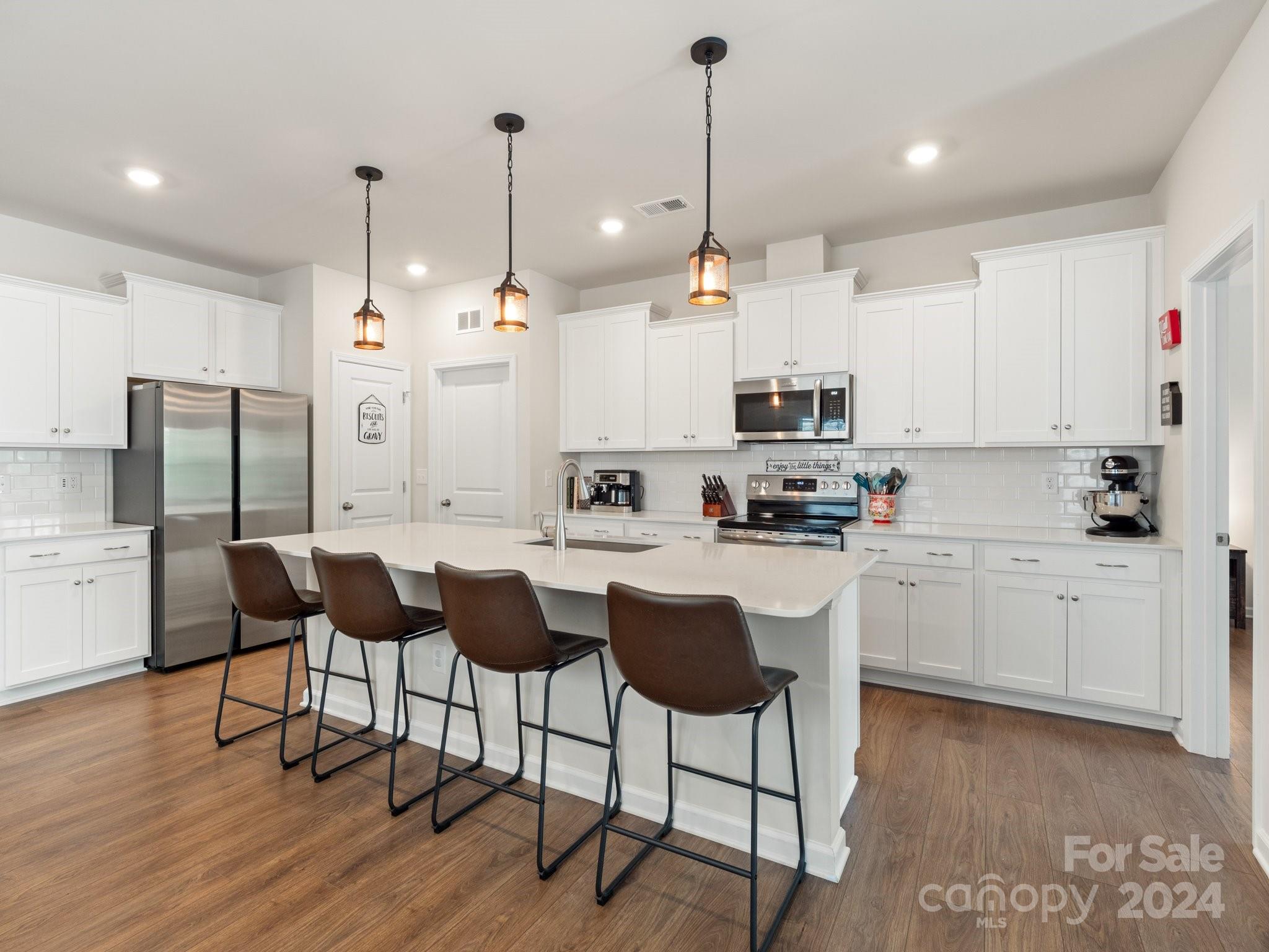6515 Gopher Road Lancaster, SC 29720 - Photo 10 of 35 a kitchen with stainless steel appliances kitchen island granite countertop a sink a stove a refrigerator and island with wooden floor