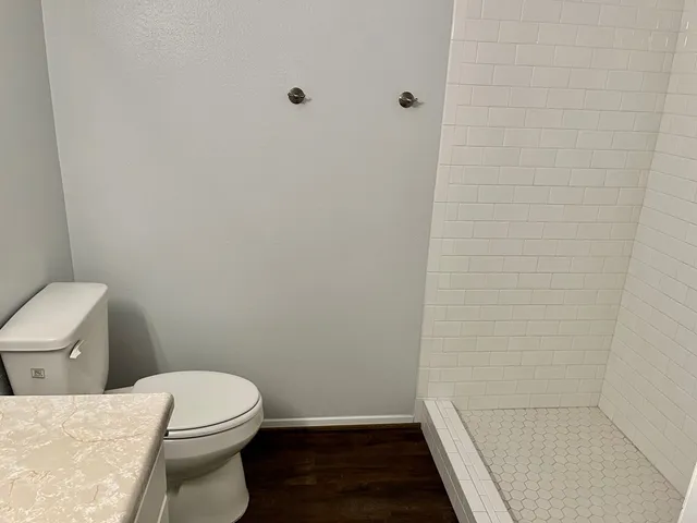 a white toilet sitting next to a shower