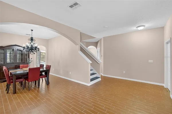 a dining room with furniture a chandelier and wooden floor