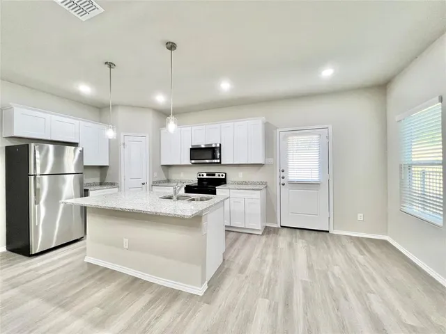 a kitchen with granite countertop a sink and a stove top oven