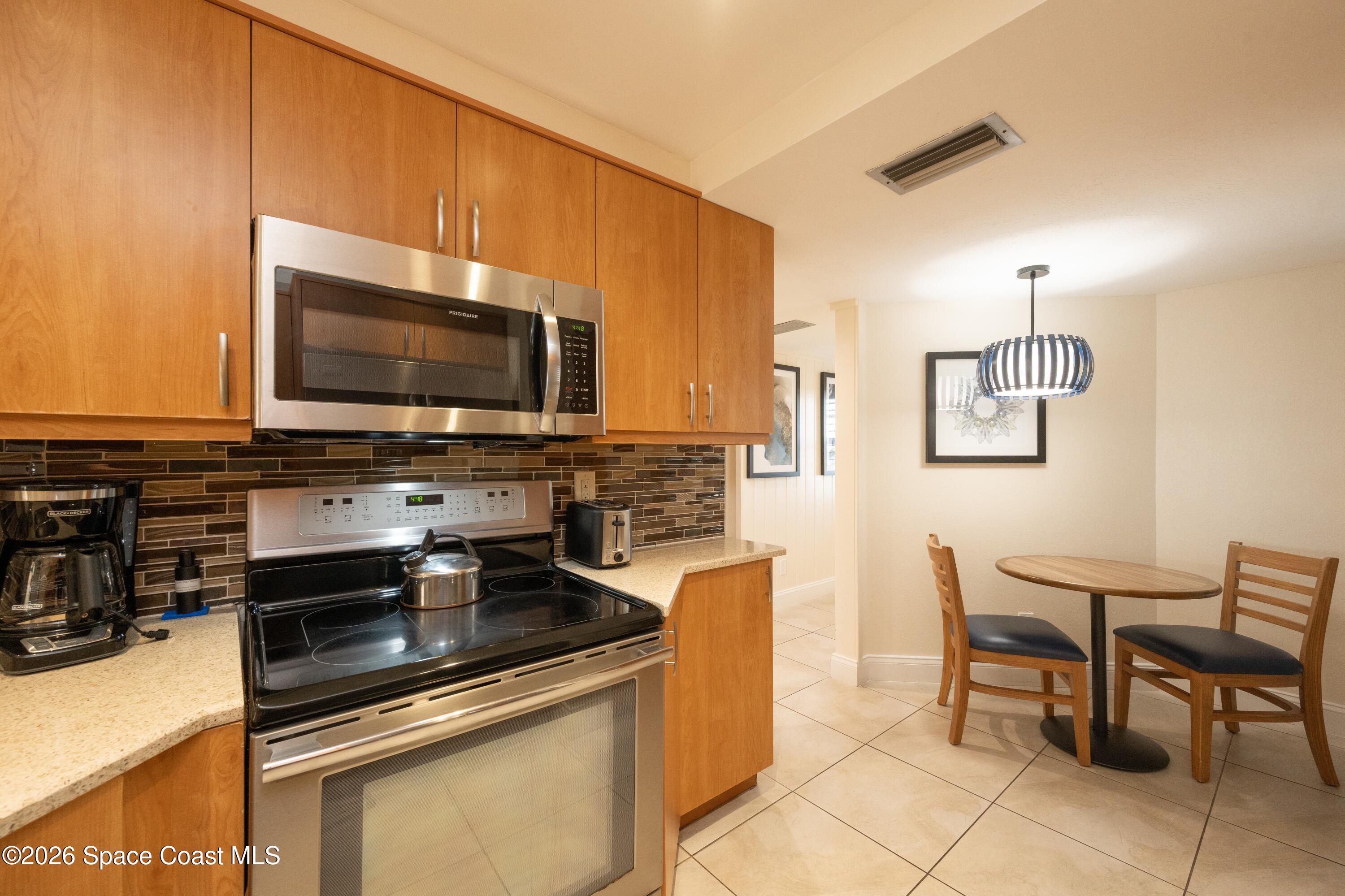 617 Front Street, Unit A52 Key West, FL 33040 - Photo 25 of 42 a kitchen with stainless steel appliances a stove a sink and a microwave