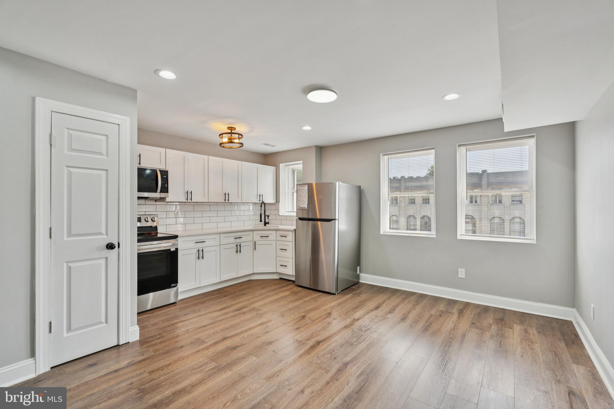 a kitchen with stainless steel appliances granite countertop a refrigerator and a stove top oven
