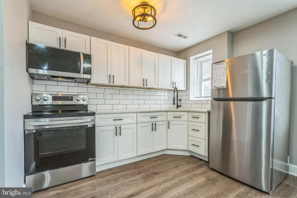 a kitchen with stainless steel appliances granite countertop a stove a refrigerator and a microwave