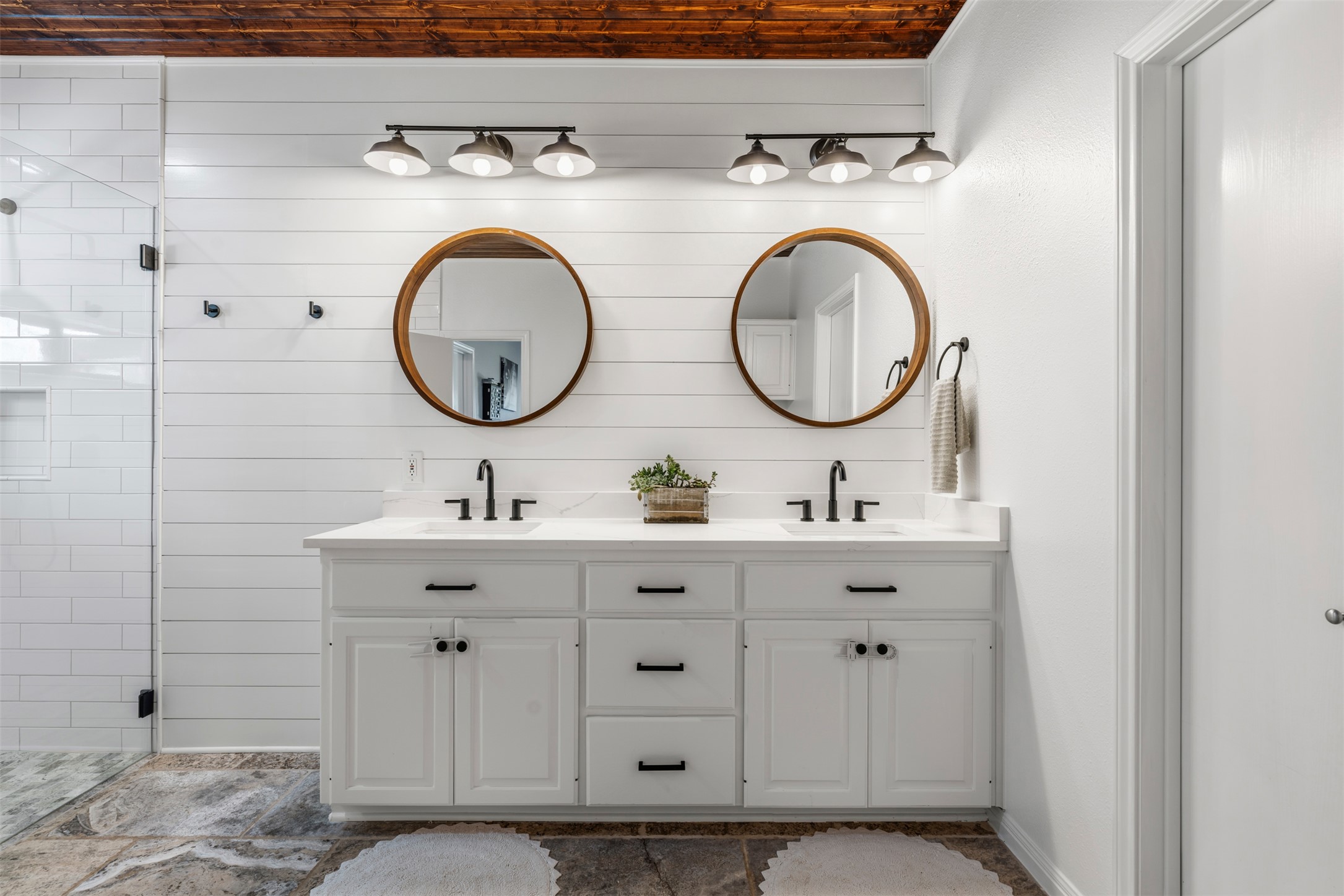 208 Amandas Way Leander, TX 78641 - Photo 12 of 25 Full bathroom with double vanity, a stall shower, and wood walls
