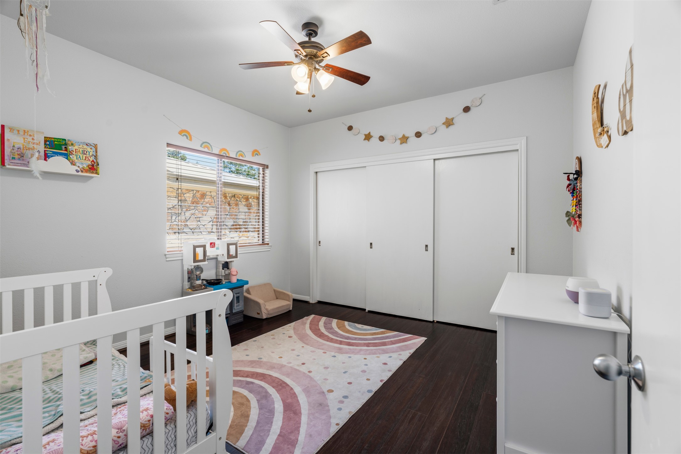 208 Amandas Way Leander, TX 78641 - Photo 13 of 25 Bedroom featuring a closet, dark wood-style flooring, ceiling fan, and a crib