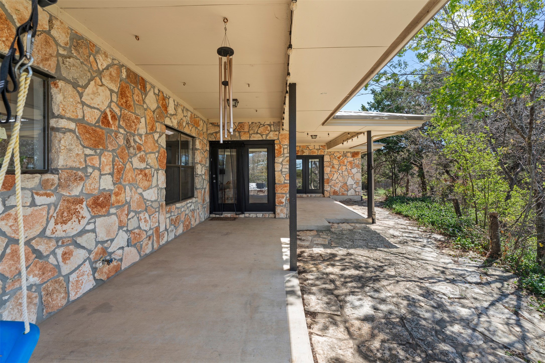 208 Amandas Way Leander, TX 78641 - Photo 20 of 25 Doorway to property with stone siding and a patio