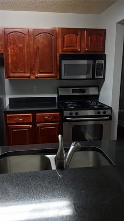 a kitchen with stainless steel appliances granite countertop a stove and a microwave