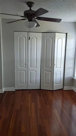a view of empty room with wooden floor and windows