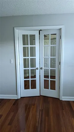 a view of a room with wooden floor and tv on a dresser