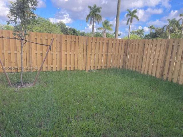 a view of a yard with wooden fence