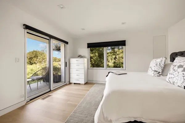 a spacious bedroom with a large window and front door