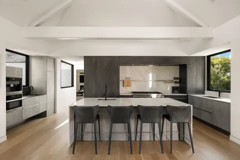 a kitchen with stainless steel appliances kitchen island granite countertop a table and chairs in it