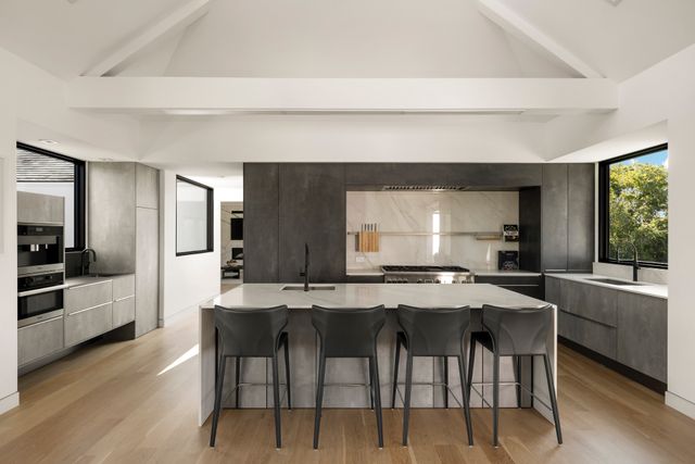 a kitchen with stainless steel appliances kitchen island granite countertop a table and chairs in it