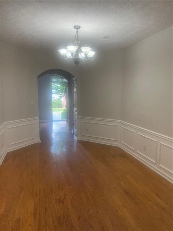 3809 Dandridge Way Northwest Duluth, GA 30096 - Photo 12 of 12 an empty room with wooden floor and chandelier