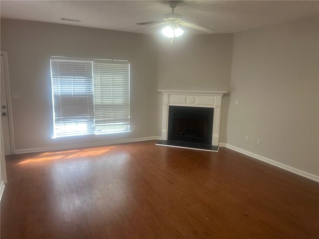 3809 Dandridge Way Northwest Duluth, GA 30096 - Photo 7 of 12 an empty room with a fireplace and wooden floor