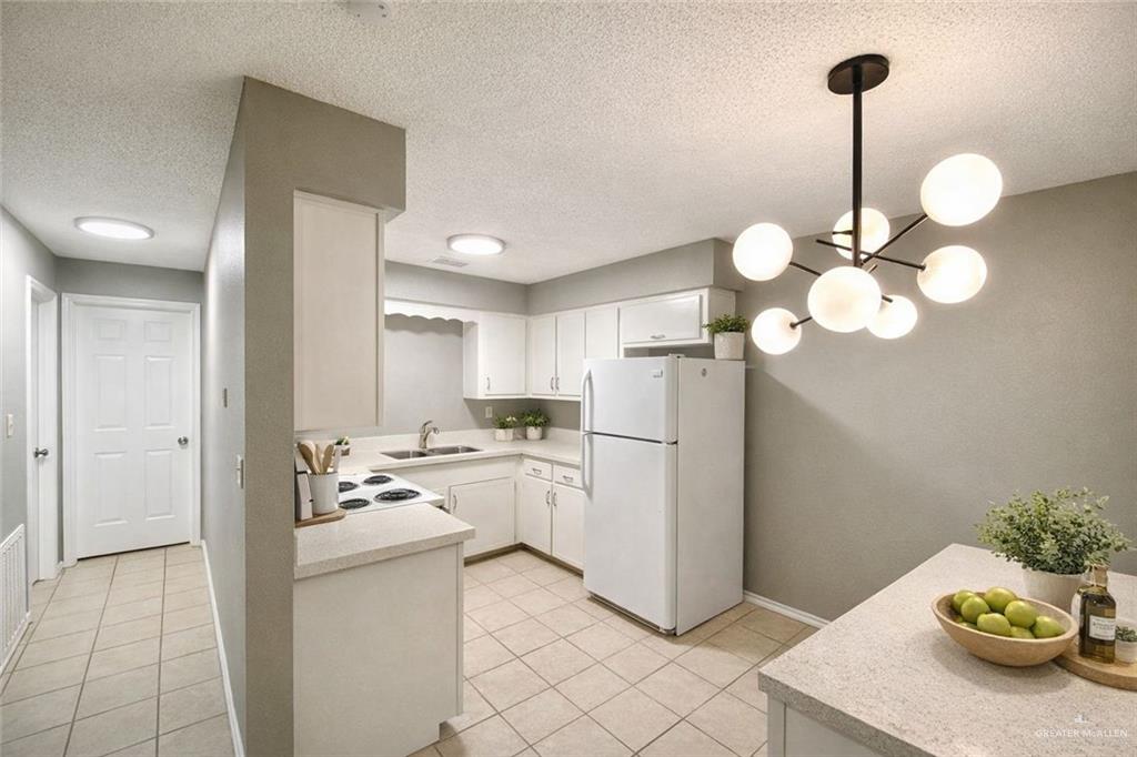 506 North McColl Road Edinburg, TX 78541 - Photo 3 of 8 a kitchen with stainless steel appliances granite countertop a sink a stove a refrigerator a chimney a dining table and chairs