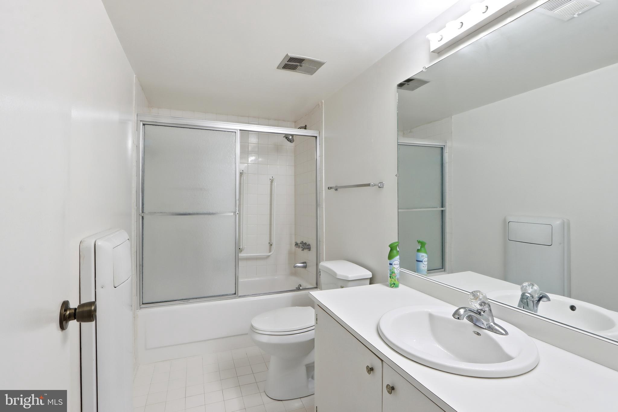 6317 Park Heights Avenue, Unit 404 Baltimore, MD 21215 - Photo 12 of 27 a bathroom with a sink toilet and shower