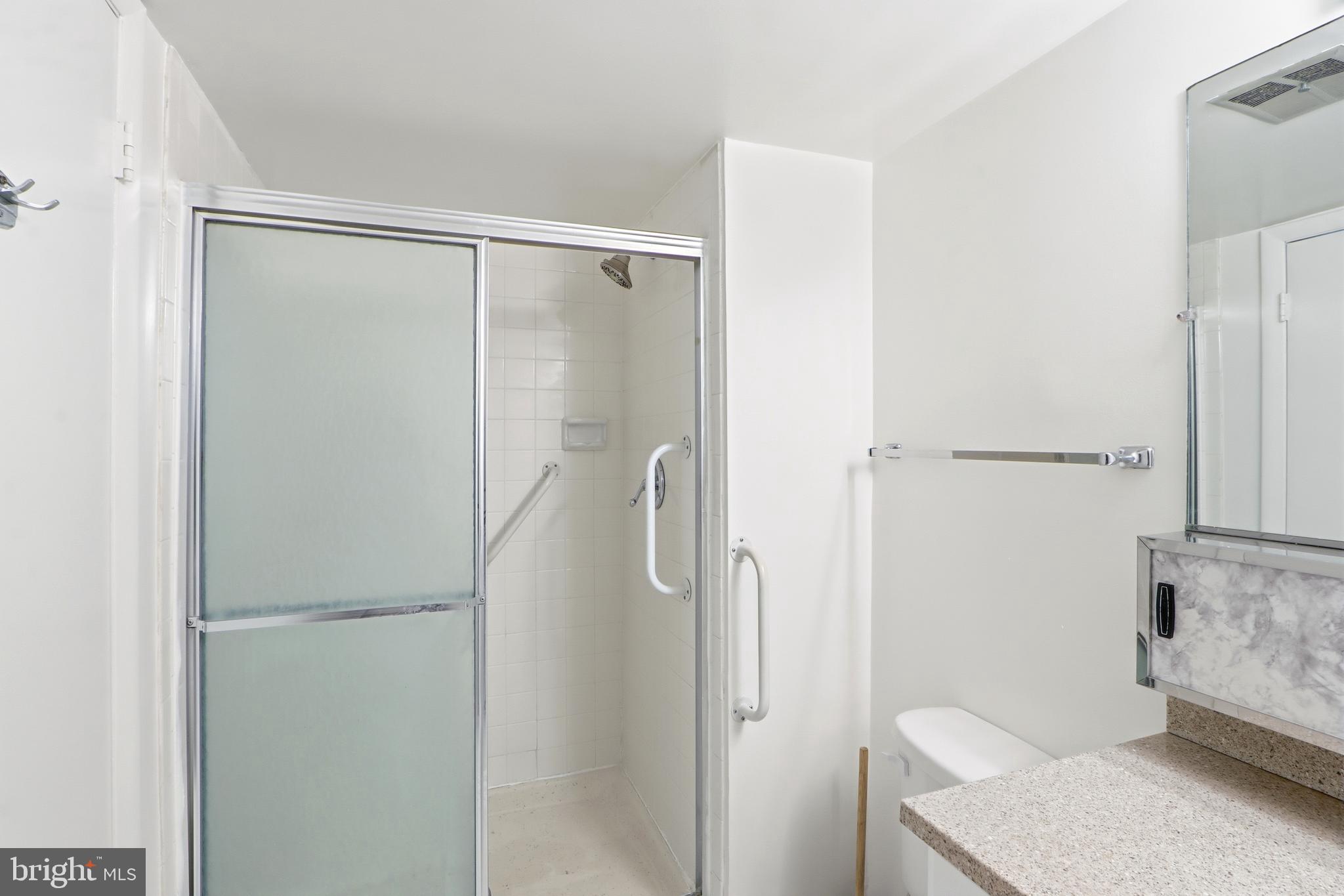 6317 Park Heights Avenue, Unit 404 Baltimore, MD 21215 - Photo 18 of 27 a bathroom with a granite countertop shower and a sink