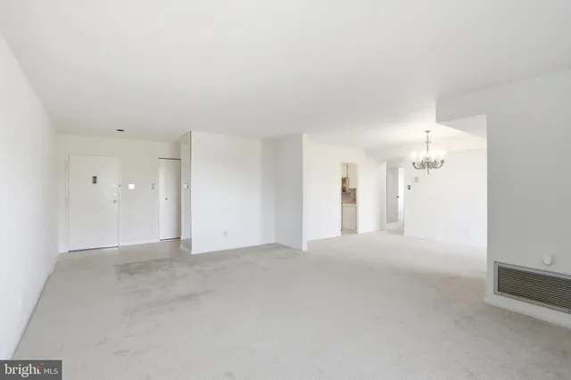 a view of a big room with windows and chandelier fan