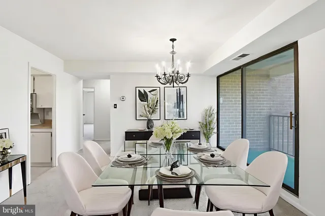 a view of a dining room with furniture a chandelier and wooden floor