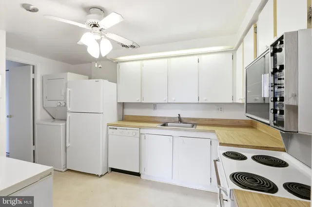 a kitchen with a sink a refrigerator and cabinets