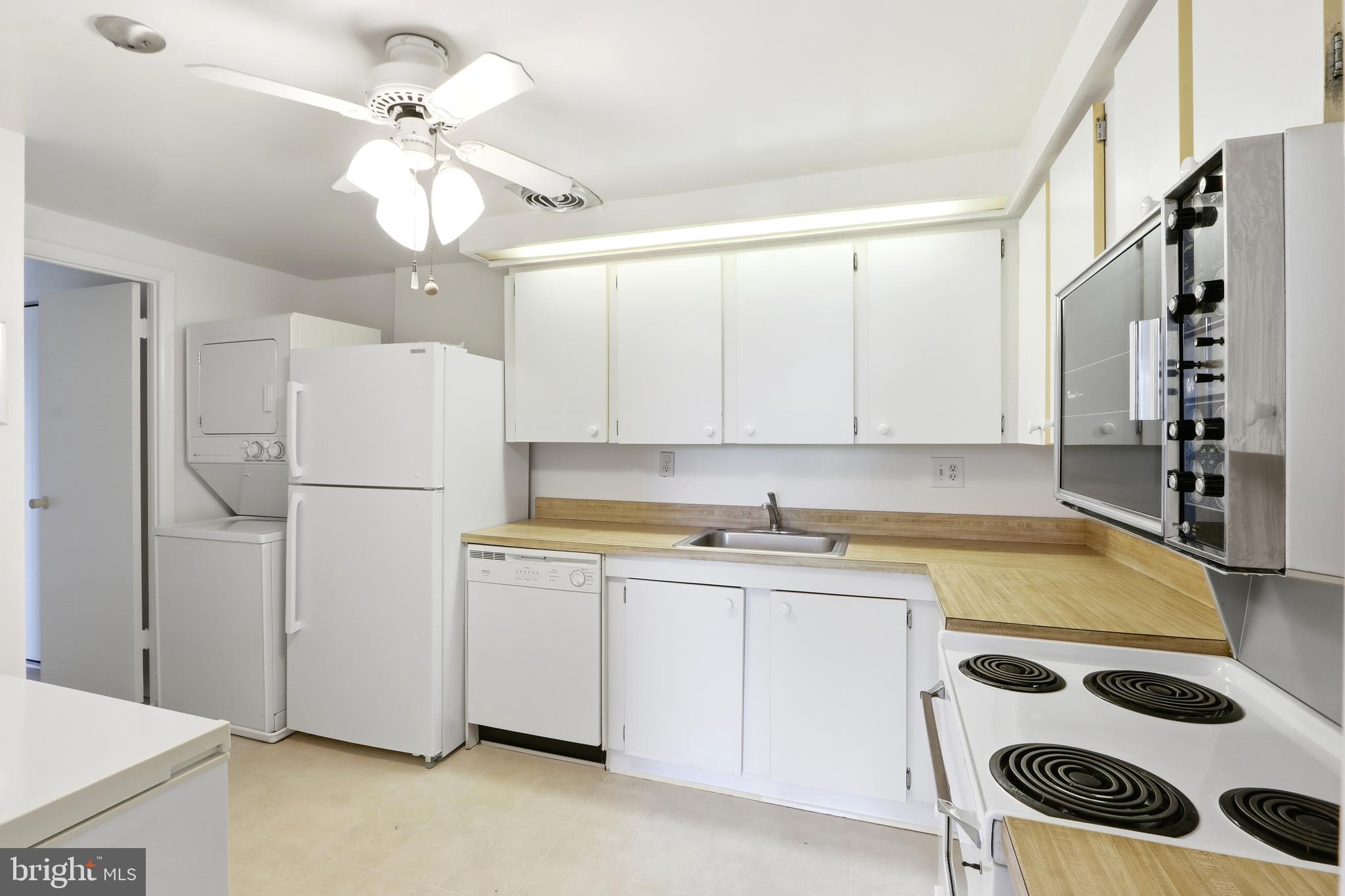 6317 Park Heights Avenue, Unit 404 Baltimore, MD 21215 - Photo 7 of 27 a kitchen with a sink a refrigerator and cabinets