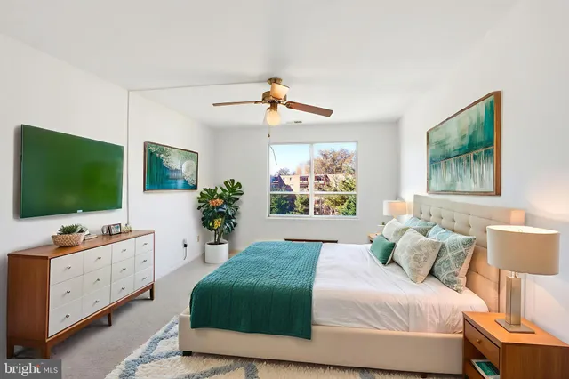 a bedroom with a bed window and flat screen tv