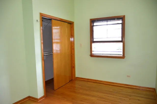 an empty room with wooden floor and a window