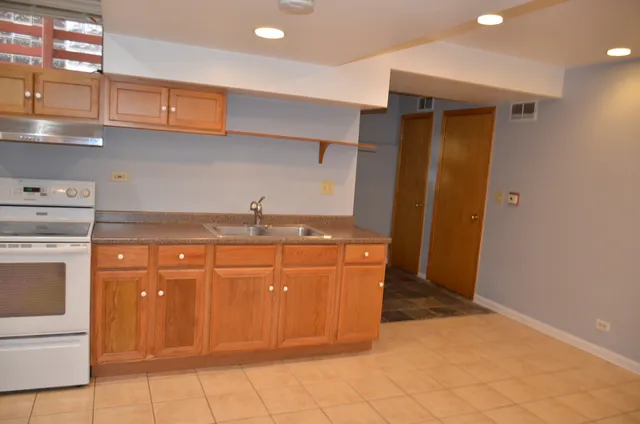 a kitchen with stainless steel appliances granite countertop a sink and a refrigerator