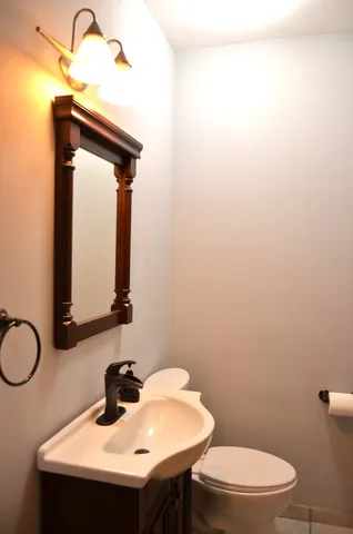 a bathroom with a sink a toilet and mirror