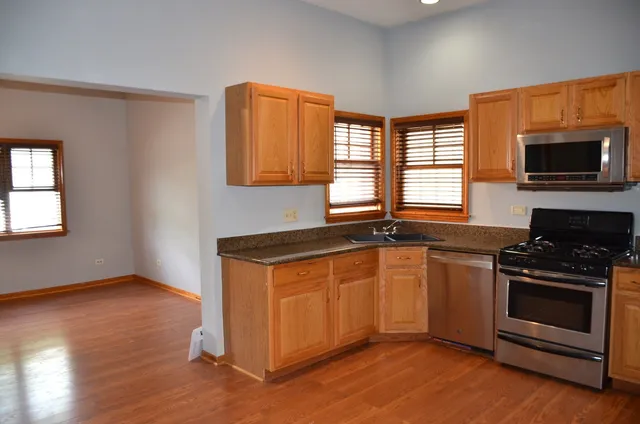 a kitchen with granite countertop wooden floors and stainless steel appliances