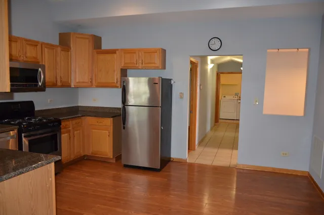 a kitchen with a refrigerator and a stove top oven