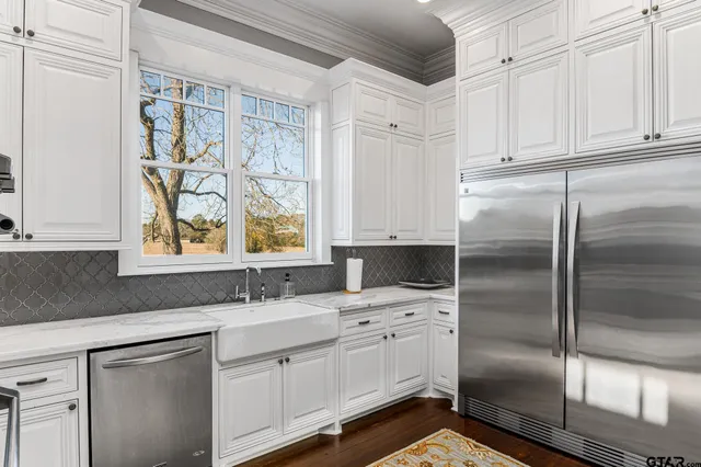 a kitchen with white cabinets and refrigerator