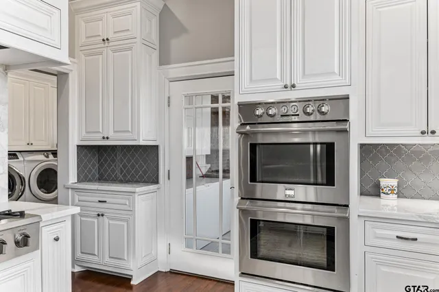 a kitchen with white cabinets and stainless steel appliances