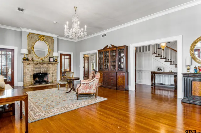 a living room with furniture a fireplace and a chandelier