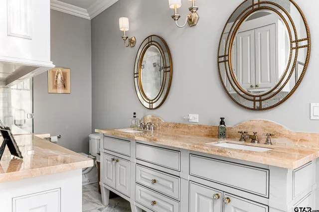 a bathroom with a granite countertop double vanity sinks and a mirror