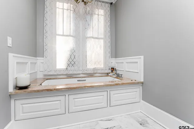 a bathroom with a granite countertop sink and window