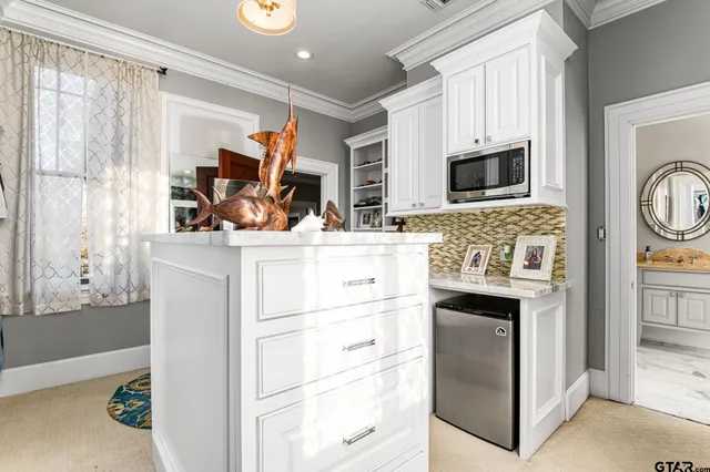 a kitchen with kitchen island white cabinets and refrigerator