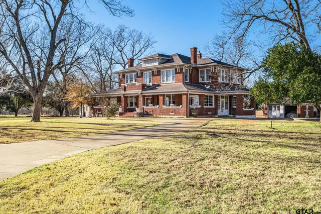 a front view of residential houses with yard and trees