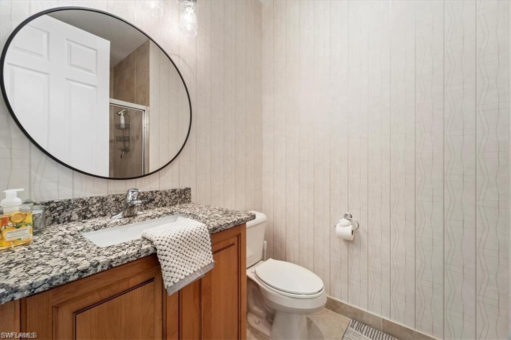 6670 Marbella Lane Naples, FL 34105 - Photo 18 of 24 a bathroom with a granite countertop sink and a mirror