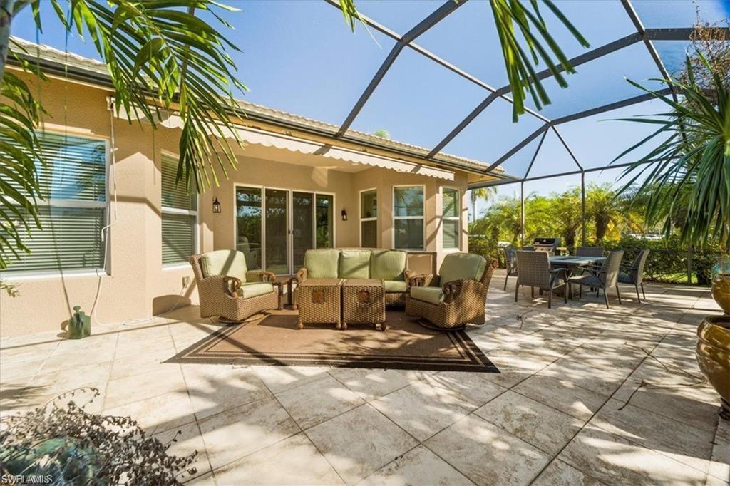 6670 Marbella Lane Naples, FL 34105 - Photo 20 of 24 a view of the patio with a table and chairs under an umbrella