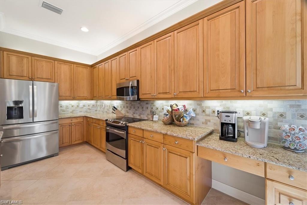6670 Marbella Lane Naples, FL 34105 - Photo 8 of 24 a kitchen with stainless steel appliances granite countertop a refrigerator sink and white cabinets