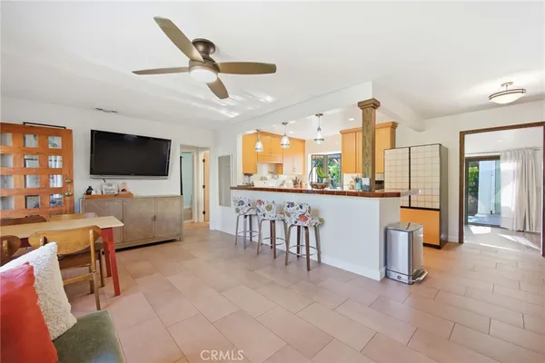 a living room with furniture a flat screen tv and kitchen view