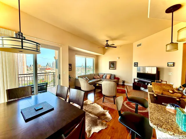 a living room with furniture a flat screen tv and a large window