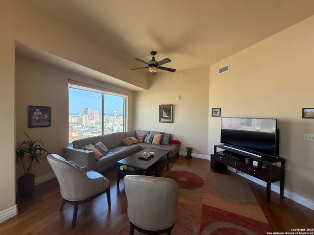 a living room with furniture a ceiling fan and a window