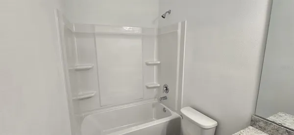 a bathroom with a granite countertop toilet a sink and shower