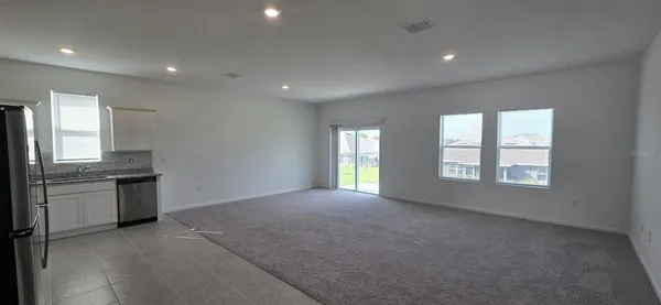 a view of an empty room with a window and fireplace
